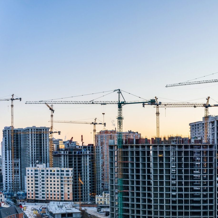 Construction,Site,Cranes,And,Multi-storey,Unfinished,Houses,At,Sunrise,Or